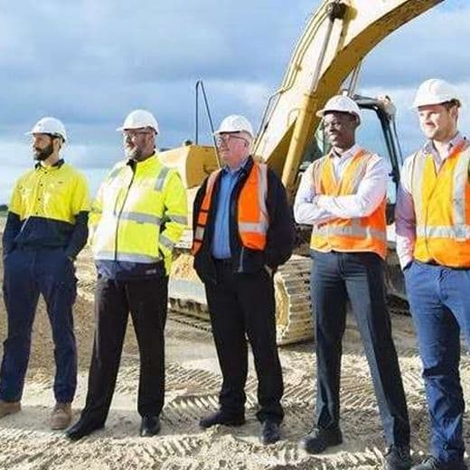 Construction workers standing in a line, wearing hi-vis clothing