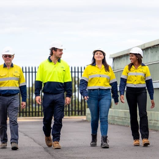 Four Aqwest employees walking towards the camera and talking.