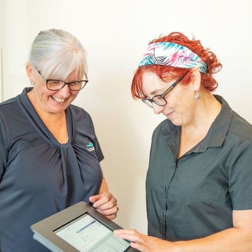 Two people using a tablet.