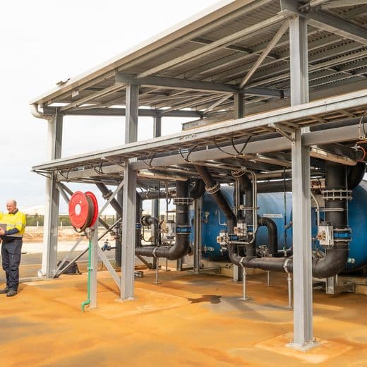 Men standing next to water plant