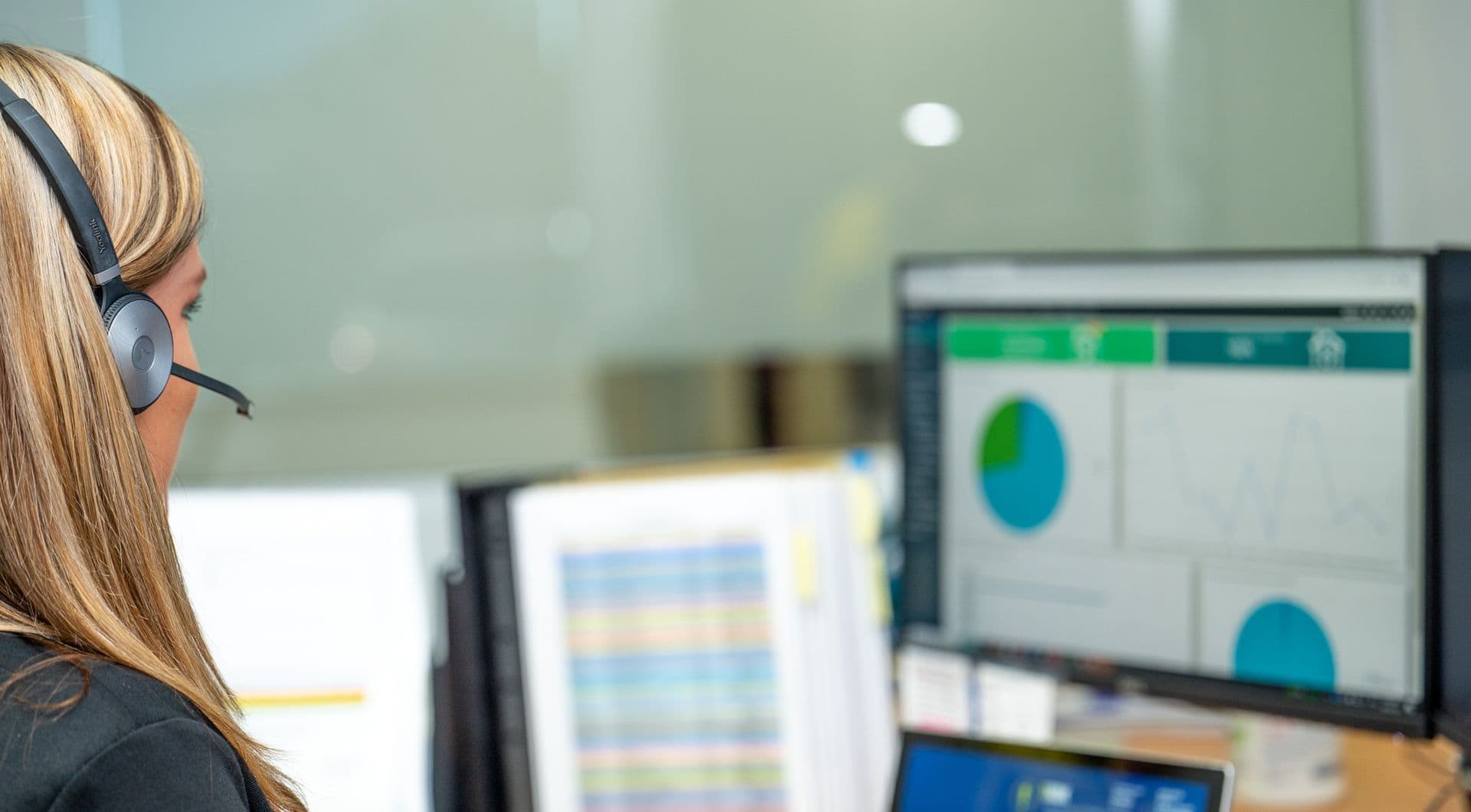 Employee sitting at desk working, looking at computer screen.