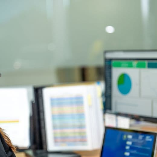 Employee sitting at desk working, looking at computer screen.