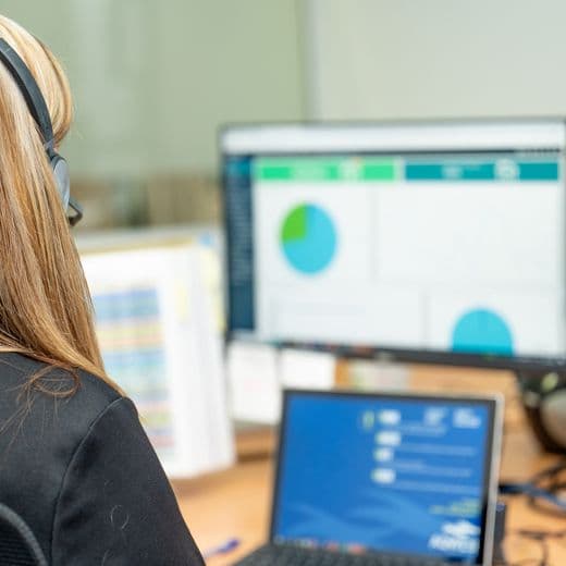 Employee sitting at desk working, looking at computer screen.