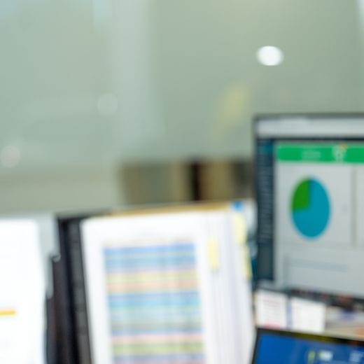 Employee sitting at desk working, looking at computer screen.